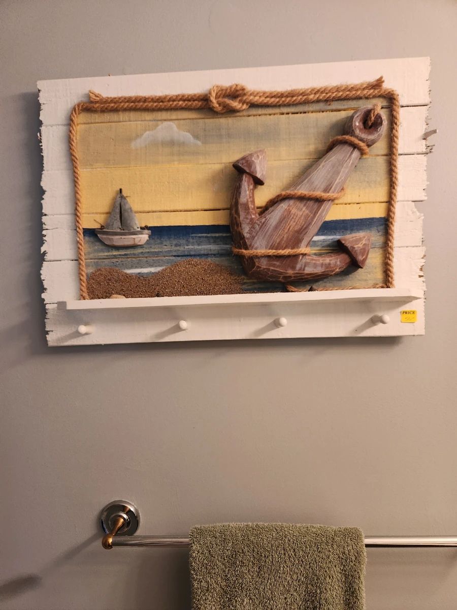 Framed coastal artwork showing a pelican and sailboats at a Williamsburg estate sale