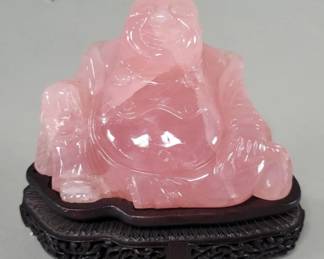 558 Hand carved rose quartz Buddha figure on a wood