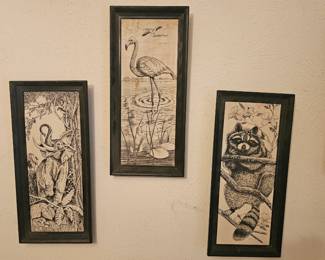 A vintage set of three framed wildlife ink prints of an elephant, flamingo, and raccoon.