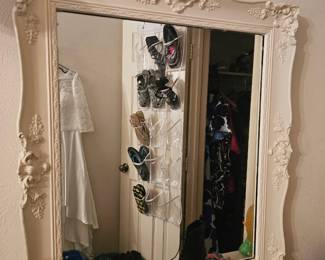 This is a large cream-colored resin framed decorative wall mirror.