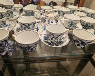 A collection of Blue Danube porcelain teacups and saucers in the blue onion pattern.