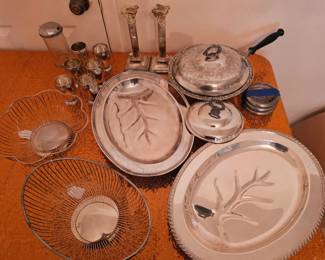A collection of vintage silver-plated serving pieces including well-and-tree platters by MW Rogers.