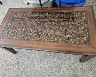 A modern rectangular wooden coffee table with an inset mosaic tile top.