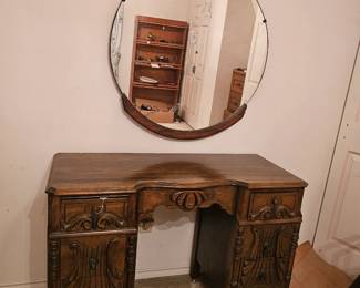 This is a vintage mid-20th century carved walnut vanity table with a matching round mirror.