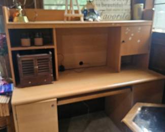 A modern light laminate home office computer desk with an attached hutch.
