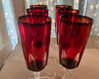 A set of vintage Cristal d'Arques Gothic ruby red champagne flutes.