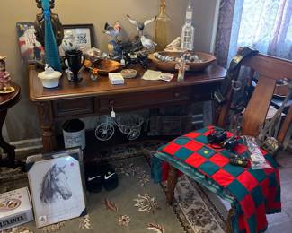 lots of knick knacks, quilt, desk and chair.