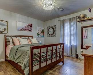 queen size bed with lots of art on walls.