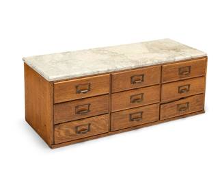 3220 An American oak spool cabinet 20th century With nine drawers below a marble top Height 15 1/2 in., width 40 in., depth 16 1/4 in. Estimate: $500 - $700