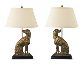 3215 A pair of English brass dog-form table lamps Mid-20th century Each single-light lamp with brass seated dog form door stop later mounted on a carved wood enameled wood base, surmounted by a fabric-lined shade, electrified Each unmarked Height of each without harp 18 in., width 9 3/4 in., depth 4 1/4 in.; height of shades 8 3/8 in., width 14 3/8 in., depth 8 3/8 in. Estimate: $400 - $600