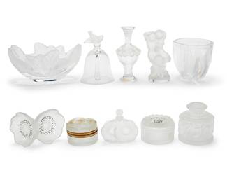 3198 A group of Lalique glass dressing table articles and vases Late 20th/early 21st century Comprising a 'Martine' perfume bottle, 'Daphne' powder box, 'Deux Tulipes' vase, 'Dahlia' powder box, 'Two Anemones' perfume bottle stopper, 'Compiegne' oak leaf bowl, 'Deux Fleurs' perfume bottle, a 'Le Faune' paperweight, and a sparrow table bell Nine etched: Lalique ® France; one etched: Lalique France 10 pieces Height of bowl 3 7/8 in., width 7 7/8 in., depth 6 in. Estimate: $1,000 - $2,000