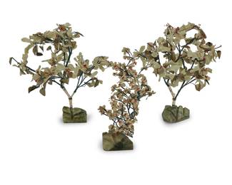 3133 Three Chinese carved hardstone trees First half 20th century Each decorated with hardstone flowers and leaves, affixed to woven fabric-encased and pliable branches, stemming from a hardstone base, comprising a near-pair and a smaller single 3 pieces Height of pair 18 3/4 in., diameter 15 in. approximately; height of single 15 in. Estimate: $500 - $700