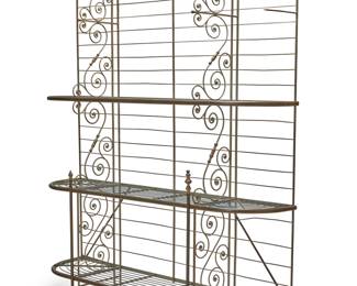 3099 A French baker's rack Early 20th century Brass and metal alloy, with laddered back and three tiers of removable wire shelving between two scroll supports Height 94 3/4 in., width 79 1/4 in., depth 20 in. Estimate: $300 - $500