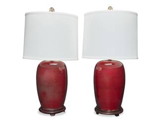 3191 A pair of Chinese glazed pottery jars mounted as table lamps Second half 20th century With deep red/oxblood glazes, each mounted to a wood base issuing a single light, surmounted by a fabric shade and brass medallion finial, electrified Each appears unmarked 2 pieces Height of each jar 15 1/2 in., diameter 10 1/4 in.; height of lamps overall 34 in.; height of shades 13 1/2 in., diameter 17 1/2 in. Estimate: $300 - $500