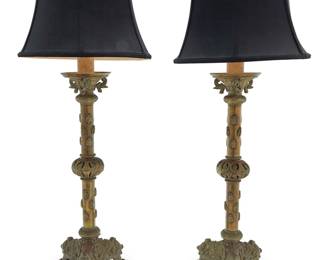 3127 A pair of Continental brass prickets mounted as table lamps 19th century with later elements With Renaissance Revival motifs, the standards applied with bees, each on a tripod base and issuing a faux candle and single-light fixture, surmounted by a fabric shade, electrified 2 pieces Height of each stick 23 3/8 in., width 9 in., depth 8 1/4 in.; height of each overall 35 1/2 in.; height of shades 9 1/4 in., diameter 14 1/2 in. Estimate: $400 - $600