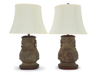 3306 A pair of Lawrence & Scott Chinese Hu style lamps Late 20th century Each patinated metal base in the style of an archaic urn, issuing two lights with a fabric shade, electrified 2 pieces Height of lamps overall 31 in., width 10 in., depth 7 in.; height of shades 13 in., width 18 1/4 in., depth 12 5/8 in. Estimate: $700 - $900