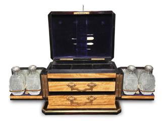 3236 A Victorian brass mounted coromandel dressing case Late 19th century The wood case with brass trimming, opening to reveal a velvet-lined interior with four glass bottles each with sterling silver cap, and two drawers, the top with fitted interior Each bottle cap with British hallmarks for sterling Height 7 1/2 in., width 12 3/8 in., depth 9 3/8 in. Estimate: $300 - $500
