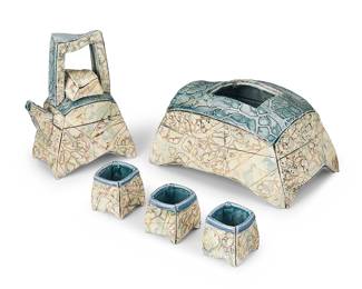 3065 A studio ceramic tea set Late 20th century Slab-built glazed ceramic, comprising a teapot and a box housing three teacups The box impressed with artist's seal 5 pieces Height of teapot 8 1/2 in., width 6 in., depth 4 3/8 in.; height of box 5 1/8 in., width 10 5/8 in., depth 6 5/8 in. Estimate: $200 - $400