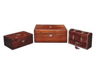 3268 Two English inlaid mahogany boxes and a tantalus 19th/early 20th century Comprising one larger box with inlaid mother of pearl accent and escutcheon, and another smaller box with inlaid brass element, trim, and escutcheon, each with locking lid opening to reveal an interior later lined with matching marbled paper, and a brass-clad wood tantalus with three glass bottles housed in a velvet-lined interior 3 pieces Height of tantalus 5 1/2 in., width 7 3/8 in., depth 3 1/4 in.; height of taller box 5 1/4 in., width 12 in., depth 8 1/2 in. Estimate: $400 - $600