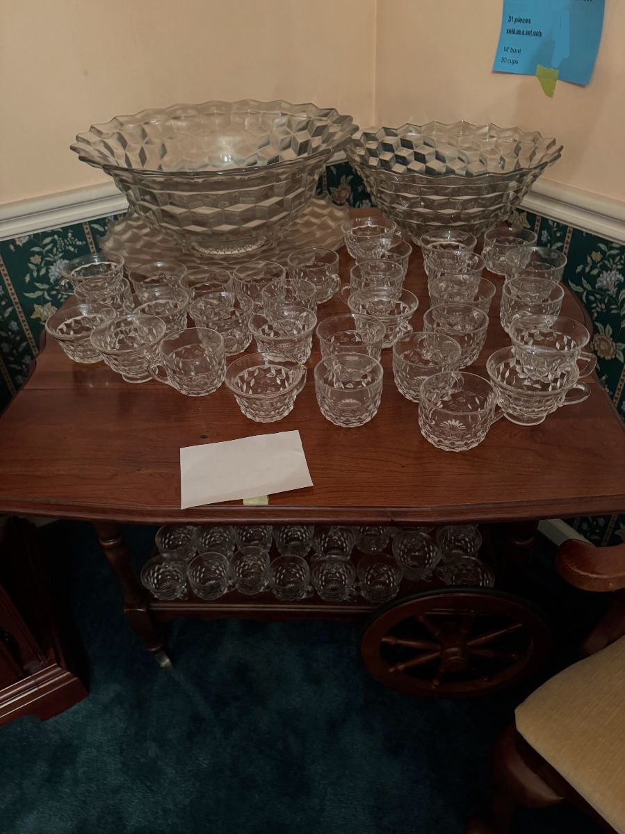 wooden serving cart displaying large Fostoria American punch bowls and numerous matching punch cups