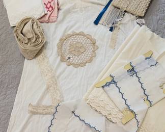 heirloom sewing lot with vintage laces and trims, eyelet and blue scalloped edging, an antique embroidered white batiste nightgown, a lace doily, and vintage children's dress patterns