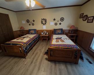 western-themed bedroom featuring A. Brandt Ranch Oak two twin wooden beds with cowboy-patterned quilts, matching nightstands, and western decorative items
