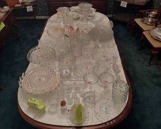 American Drew Queen Anne extension dining table completely covered with a massive collection of Fostoria Glass Company American pattern clear pressed glass tableware