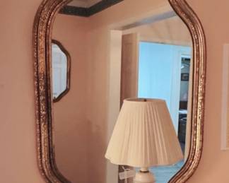 scalloped wall mirror with ornate gold frame