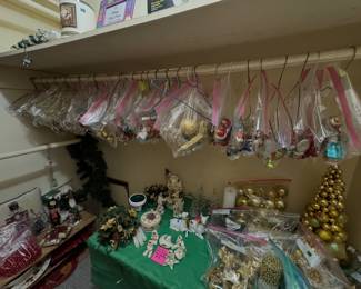 hanging plastic bags filled with Christmas ornaments, alongside holiday decor, figurines, and a gold ornament tree