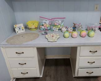 Easter décor: glitter and pastel eggs, Easter basket, bunny figurines and planters, ceramic egg trinket boxes, basket-shaped deviled egg plate, ribbon, and lace doily