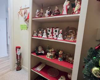 Christmas collectibles: Santa figurines, snow globes (including a nativity scene), ceramic bells, polka-dot present cookie jar, and holiday wall décor