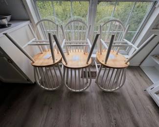white Windsor-style spindle-back chairs with natural wood seats.