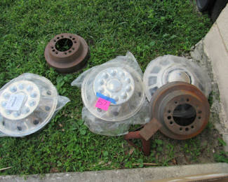 Lot 91: Truck Wheel Covers, Brake Drums, and Jack Stand