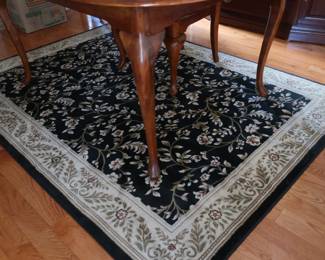 view of leg of dining room table area rug in dining room