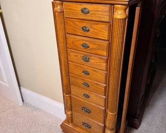 Tall wooden jewelry cabinet with multiple organizational drawers and side flip-out necklace doors