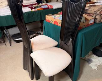 High-back black lacquered dining chairs with upholstered seats