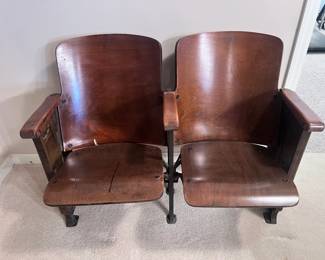 Wooden double-seat theater bench featuring ornate Art Deco metal end panels