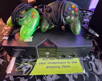 XBox console with controllers and cords.