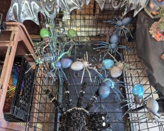 More spiders on sticks resting on a large dog cage.