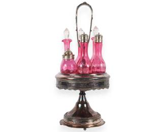 A Set of Five Victorian Cranberry Glass Bottles in an Ornate Silver-Plated Caster Stand