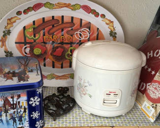 Lot 104: Rice Cooker, Barbecue Serving Tray, Decorative Tin, Cast Iron Trivet, and Cake Template