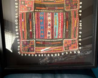 embroidered and beaded African textile framed in a shadow box