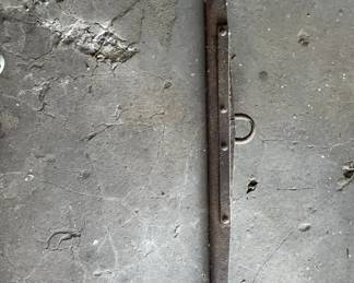 Antique Iron Singletree 1980-1920 A heavy forged iron singletree featuring a central clevis ring and end hooks for draft animal harnessing. The elongated wooden or iron bar shows weathered texture and visible fastening bolts.