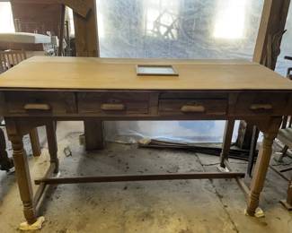 1890-1920 Railroad Desk from Conetoe depot This antique wooden railroad desk features a long rectangular top with a central inlaid document frame and a bank of four small drawers along the front apron, fitted with wooden pulls and keyhole escutcheons. The structure is supported by turned legs joined by a lower stretcher base.
