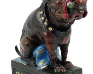 129 - Ole Puffer Cast Iron Bulldog Cigar Bank 8.5" (Description): Ole Puffer cast iron mechanical bank  featuring a seated bulldog wearing a green  bowler hat and studded collar, smoking a  cigar. The dog sits atop a rectangular base  with gold lettering reading "Cigar 5 Nickels" and "Ole Puffer." The figure is painted in  brown with red and blue accents. Measures  8.5" tall.