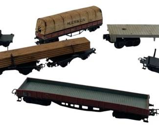 300 - Group Lot of 6 Marklin Carrier Cars (Description): Group lot of six Marklin carrier cars. This  collection includes various freight and  carrier car models suitable for model train  layouts. Measures 2 inches by 2 inches by 10  inches.