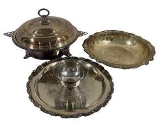 2023 - 3 Silver Plated Items (Description): A three-piece lot of silver plated items. The  lot includes a covered serving dish with  decorative handles and footed base, a  scalloped-edge bowl, and a round serving tray  with attached center bowl, all featuring ornate border designs.