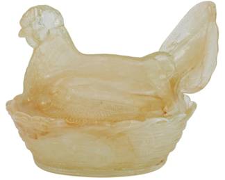 141 - Peach Slag Glass Hen on Nest Figure 5"x7"x5" (Description): Featuring a translucent pressed glass  construction with a warm amber-toned  coloring. The piece depicts a hen seated atop  a woven basket-style nest base, with  detailed feather texturing throughout the body and a raised tail. This charming covered  dish style collectible measures 5 inches  tall by 7 inches long by 5 inches wide.