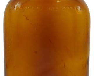 252 - Vtg 1940s Amber Liquid Bottle 8.5" (Description): Vintage 1940s amber glass liquid bottle with  original cork stopper. The bottle features a  classic flask-style shape with rounded  shoulders and embossed text on the glass.  Measures 8.5 inches tall.