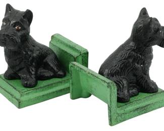 99 - Pr Cast Iron Scottish Terrier Bookends 5" (Description): Pair of cast iron bookends featuring seated  Scottish Terrier dogs. Each bookend depicts a  black Scottie dog with detailed fur texture  and glass eyes, mounted on a stepped green  painted base. Measures 5 inches. The bookends display charming vintage character with  their contrasting black and green color  scheme.